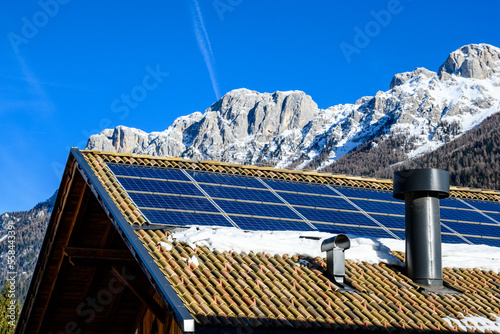 Pannelli fotovoltaici su tetto in montagna con neve  photo