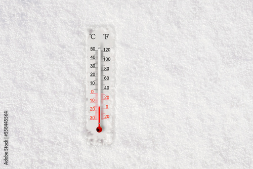 White celsius and fahrenheit scale thermometer in snow. Ambient temperature minus 15 degrees celsius