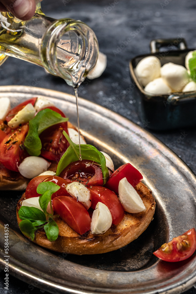 Caprese toasts with mozzarella, cherry tomatoes and fresh garden basil. Traditional italian appetizer or snack, antipasto. vertical image. top view. place for text Caprese toasts with mozzarella, cherry tomatoes and fresh garden basil. Traditional italian appetizer or snack, antipasto. vertical image. top view. place for text