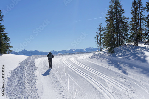 Wonderful wintertime, winter mountain landscape, sunny day. Single hiker explore the mountain route in Salzburg Alps. Active lifestyle in winter.