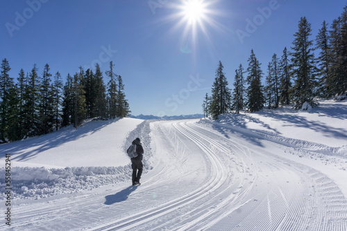 Winter mountain landscape, sunny day. Single hiker explore the mountain route in Salzburg Alps. Active lifestyle in winter. Wonderful wintertime.