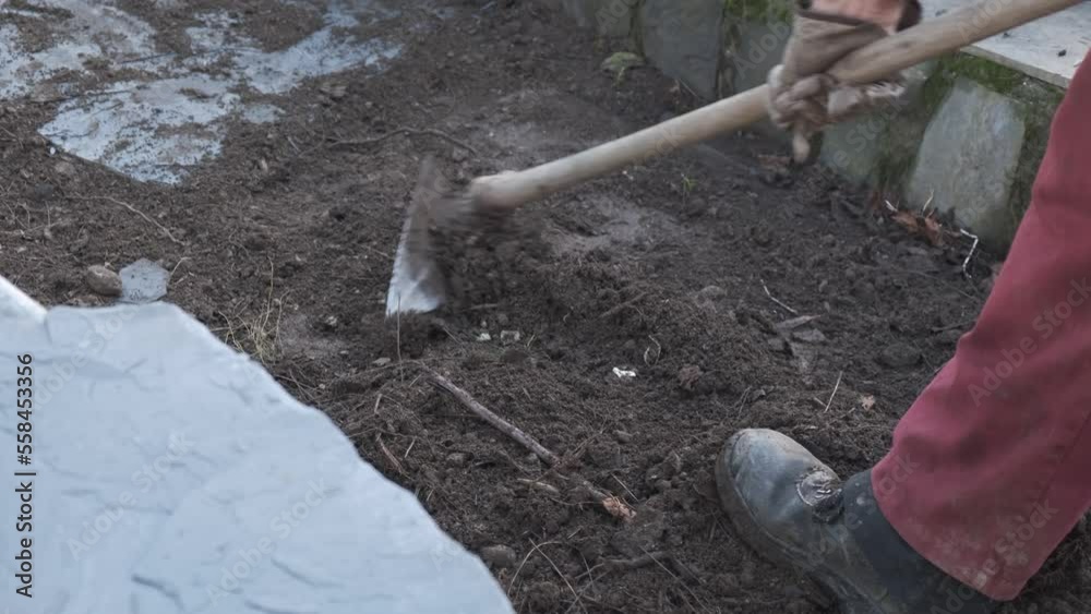 4k vídeo. Slow motion Hombre jubilado removiendo la tierra con una azada