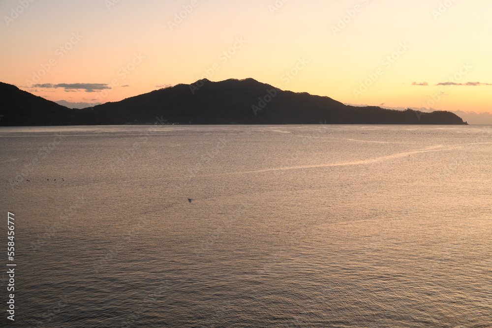 海を見渡す朝焼けと島のシルエット