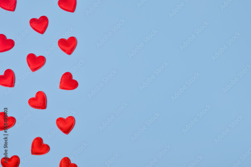 Flatlay of Small red hearts on a light blue background. Valentine's Day banner or card with copy space. Love gift concept.