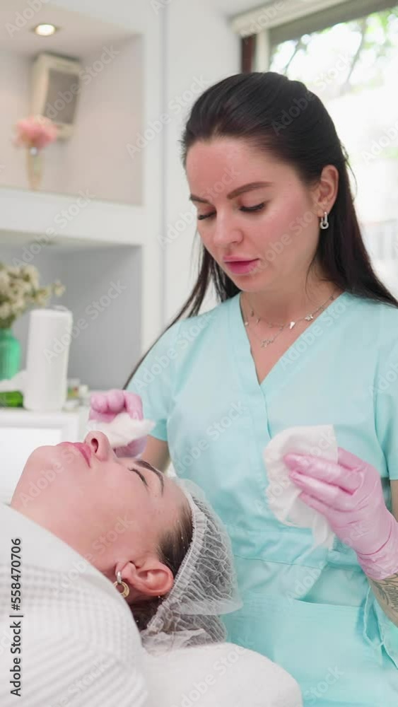 Vertical video, Woman Beautician Makes Rejuvenating Facial Skin Procedure Female Client. Professional Cosmetic Procedures in Modern Beauty Clinic and Spa Services. Concept Skincare and Cosmetology. Vertical video, Woman Beautician Makes Rejuvenating Facial Skin Procedure Female Client. Professional Cosmetic Procedures in Modern Beauty Clinic and Spa Services. Concept Skincare and Cosmetology.