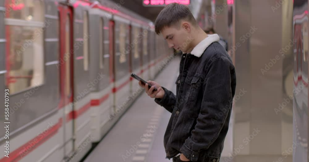 The guy uses the phone for the arrival of the train. He buys an e-ticket at the station. Flashing security strip on the station platform. Opening doors. The guy uses the phone for the arrival of the train. He buys an e-ticket at the station. Flashing security strip on the station platform. Opening doors.