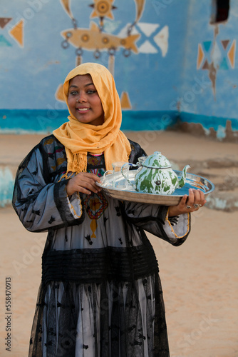 A Nubian girl carrying a teapot