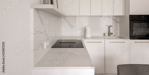 Warm white kitchen interior design, electric hob with integrated extraction. Modern kitchen interior concept