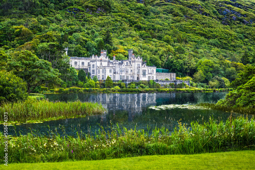 Reflection of the white Kylemore Abbey and the surrounding forest during a rainy day, Connemara, Ireland