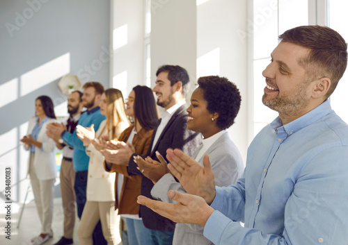 Canvas Print Smiling diverse businesspeople applaud thanking coach or presenter for talk or training
