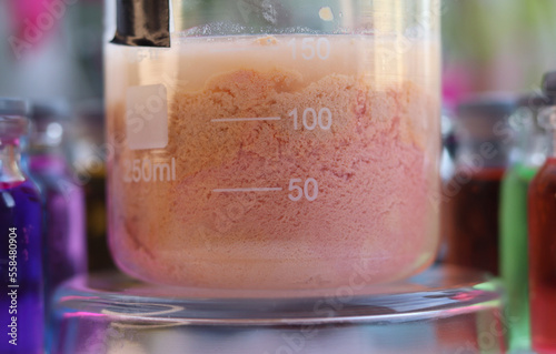 Inorganic chemical reaction of the formation of a light brown insoluble compound of manganese sulfide in a beaker.