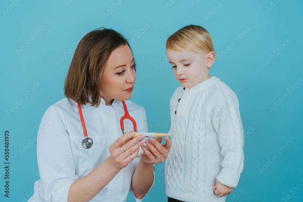 Pediatrician woman looking at thermometer with boy Pediatrician woman looking at thermometer with boy