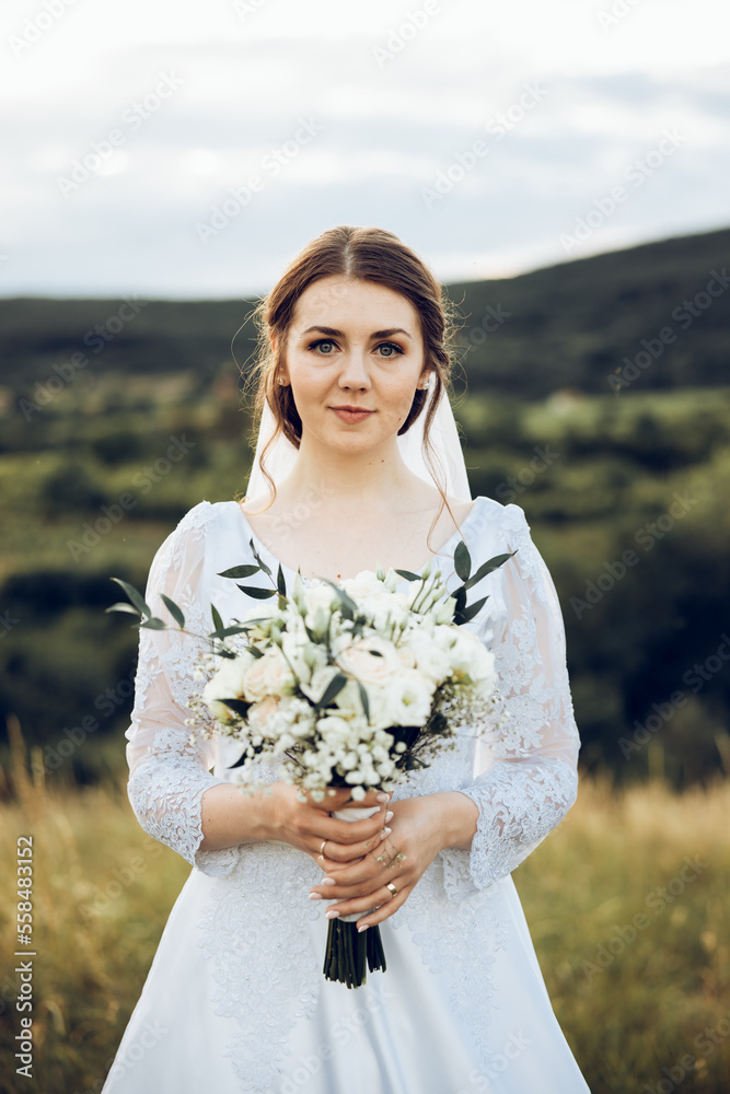 a shot of a beautiful bride in a white dress in the middle of nature, the bride is holding a beautiful bouquet a shot of a beautiful bride in a white dress in the middle of nature, the bride is holding a beautiful bouquet
