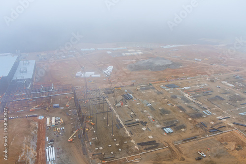 Construction site in when there is heavy fog an ground during use of cranes working on commercial buildings