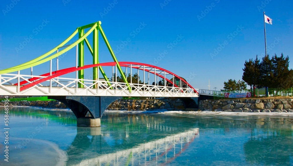 Reflection of colorful bridge on the partial frozen river in winter in South Korea
