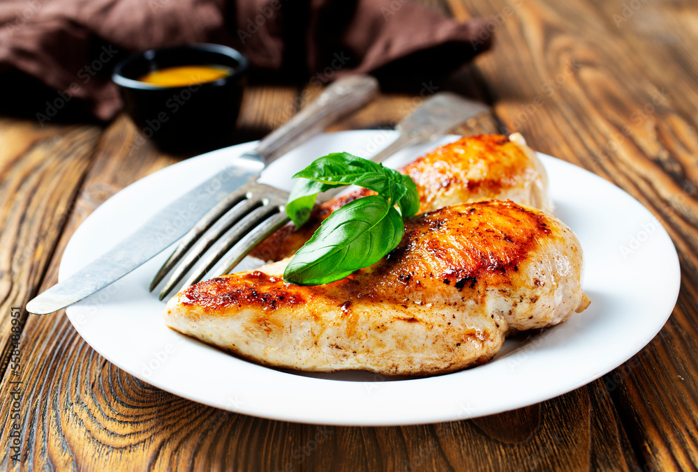 Marinated grilled healthy chicken breasts cooked on a summer BBQ and served with fresh herbs and lemon juice Marinated grilled healthy chicken breasts cooked on a summer BBQ and served with fresh herbs and lemon juice