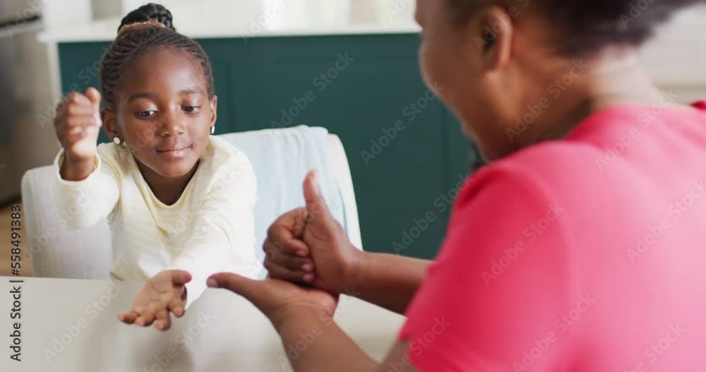 Video of smiling african american granddaughter using sign language with grandmother, copy space