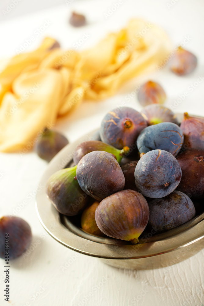 Fototapeta premium A few figs in a bowl on an old light background.