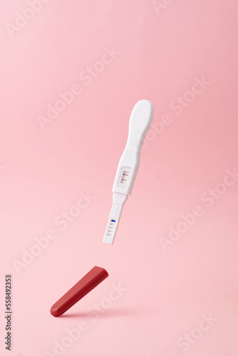 Positive pregnancy test on pink background