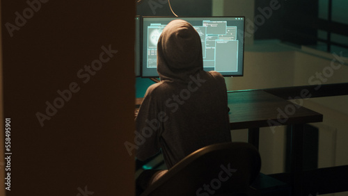 Female spy breaking into computer firewall to hack system, feeling happy about cybercrime success. Woman using malware or trojan virus, doing phishing espionage for hacktivism. Handheld shot.