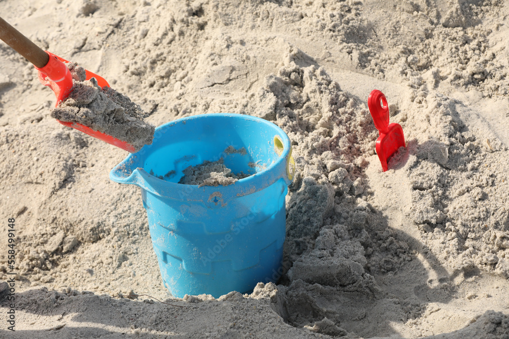 blue bucket and shovel in the sand at the beach blue bucket and shovel in the sand at the beach