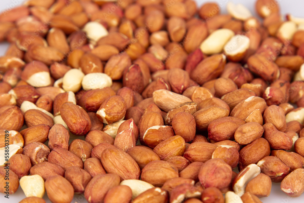 A lot of unpeeled peanuts isolated on a white background. Clipping path. Full depth of field. background image. A lot of unpeeled peanuts isolated on a white background. Clipping path. Full depth of field. background image.