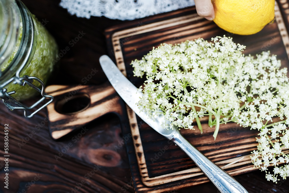 Ingredients for a refreshing drink of elderberry and lemon. Knife on a cutting board.