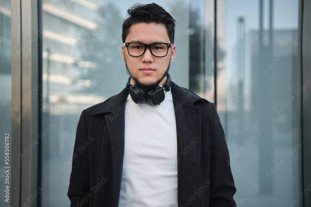 An Asian guy businessman in a headphones mid shot, outdoor An Asian guy businessman in a headphones mid shot, outdoor