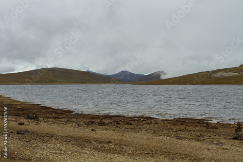 Landscape of the Andes of Peru in a lagoon with rocks piled up around it. Concept of nature and landscapes of South America. (Pomacocha, Perú) photo