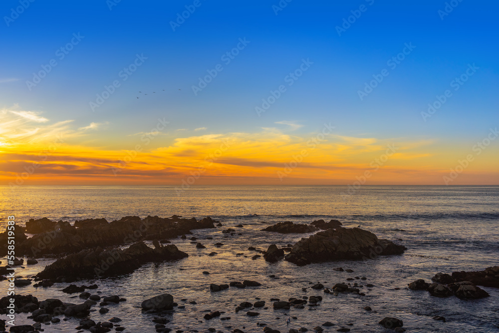 A wide view of a sunset of the Monterey Bay in California