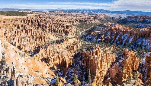 Panorama of Bryce Canyon accented in freshly fallen snow and distant mountains