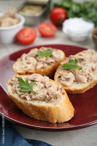 Tasty sandwiches with cod liver and parsley on light grey table