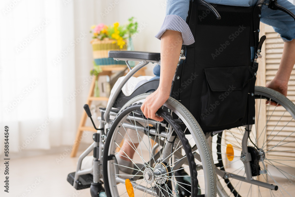 Obraz premium 車椅子をこぐ若い女性 多様性社会イメージ