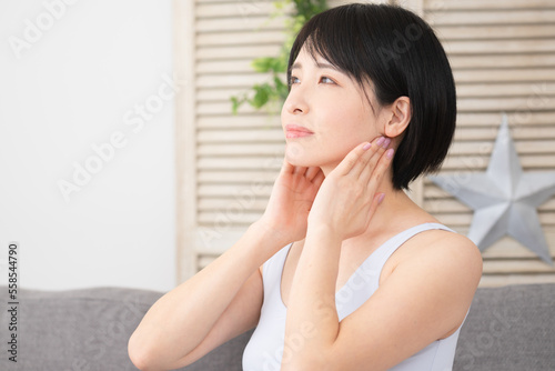 耳下腺のセルフマッサージをする若い女性　美容イメージ photo