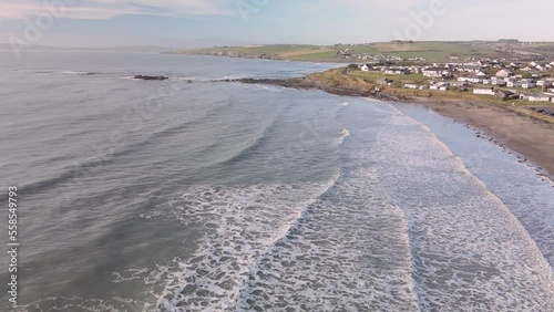 Waves foaming and crushing on sandy beach in slow motion, an aerial footage during winter morning in Ireland photo