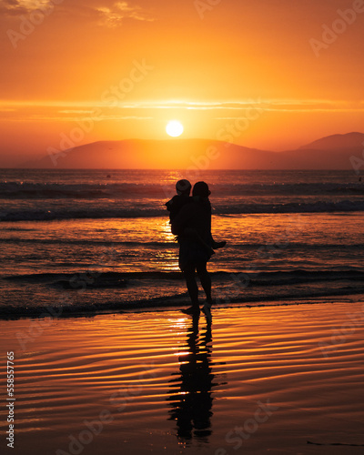 Mother and son staring off to the sunset