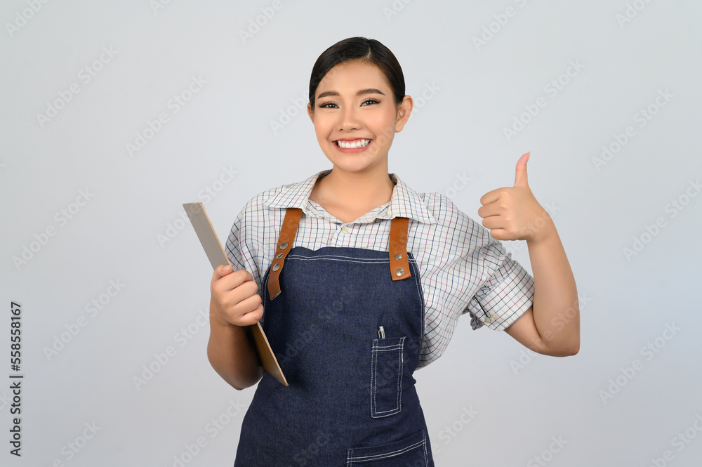 Portrait of young asian woman in waitress uniform pose with clipboard Portrait of young asian woman in waitress uniform pose with clipboard