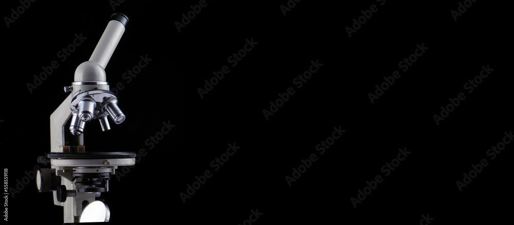 A microscope with three lenses on a black background. A microscope with three lenses on a black background.