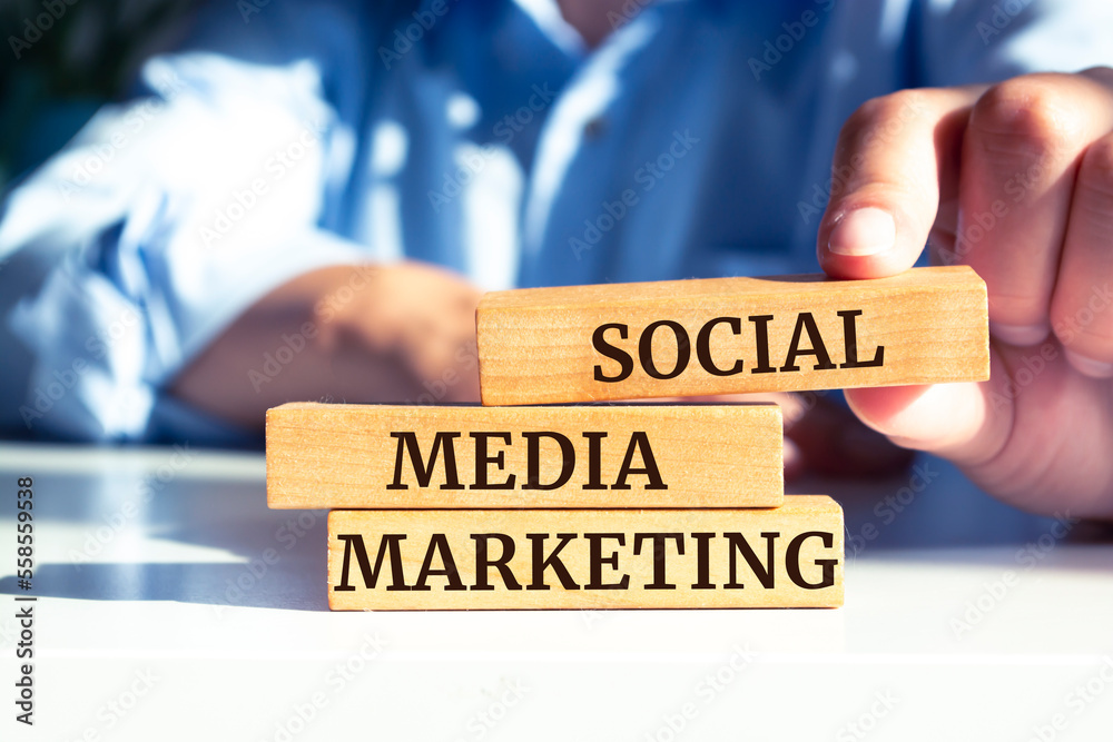 Closeup on businessman holding a wooden blocks with text SOCIAL MEDIA MARKETING, business concept Closeup on businessman holding a wooden blocks with text SOCIAL MEDIA MARKETING, business concept