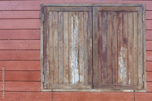 Old wooden window with shutters on wooden wall. The old window of old wooden house on countryside.