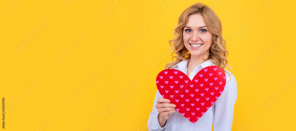 smiling woman with red love heart on yellow background. Woman isolated face portrait, banner with mock up copy space. smiling woman with red love heart on yellow background. Woman isolated face portrait, banner with mock up copy space.