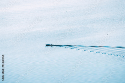 The old man and the sea. Aerial view of a lonely fishing boat on the vast expanses of the sea or lake. Psychological concept