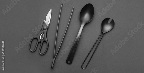 Kitchen utensils on dark background, top view photo