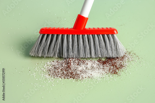 Sweeping of rubbish with broom on color background, closeup
