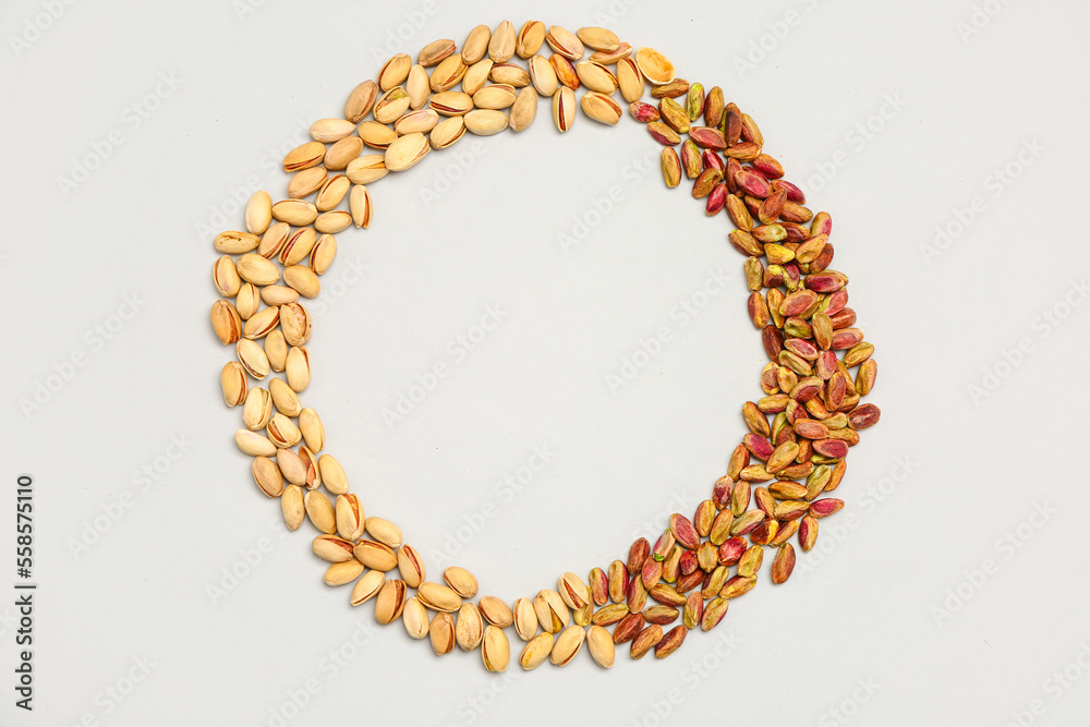 Obraz premium Frame made of tasty pistachio nuts isolated on white background