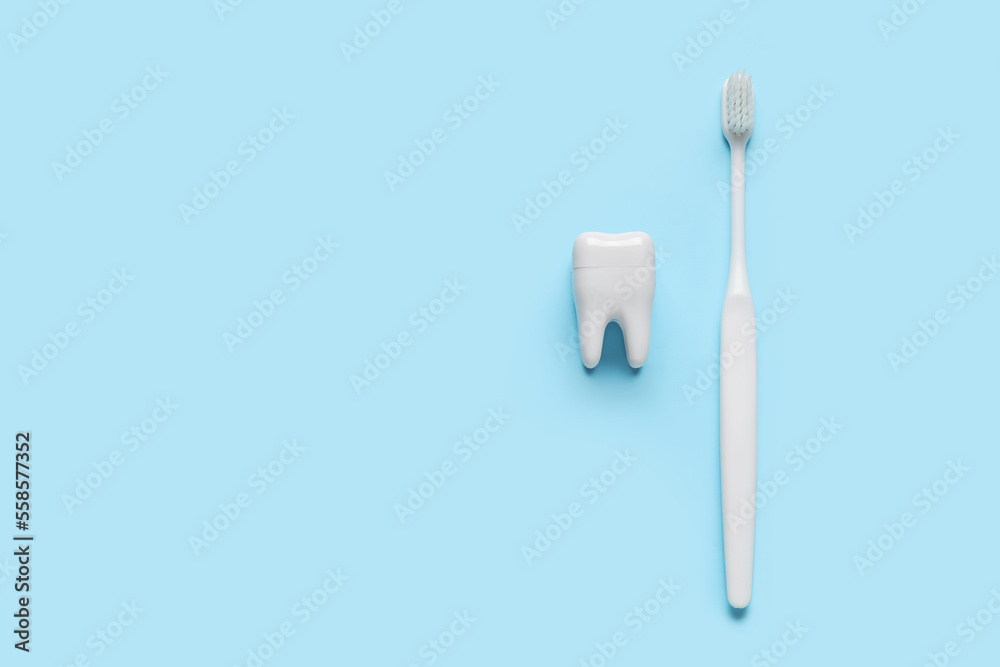 Plastic tooth with brush on blue background Plastic tooth with brush on blue background