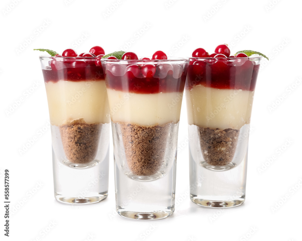 Shots of delicious pudding with cranberry, mint and jam isolated on white background