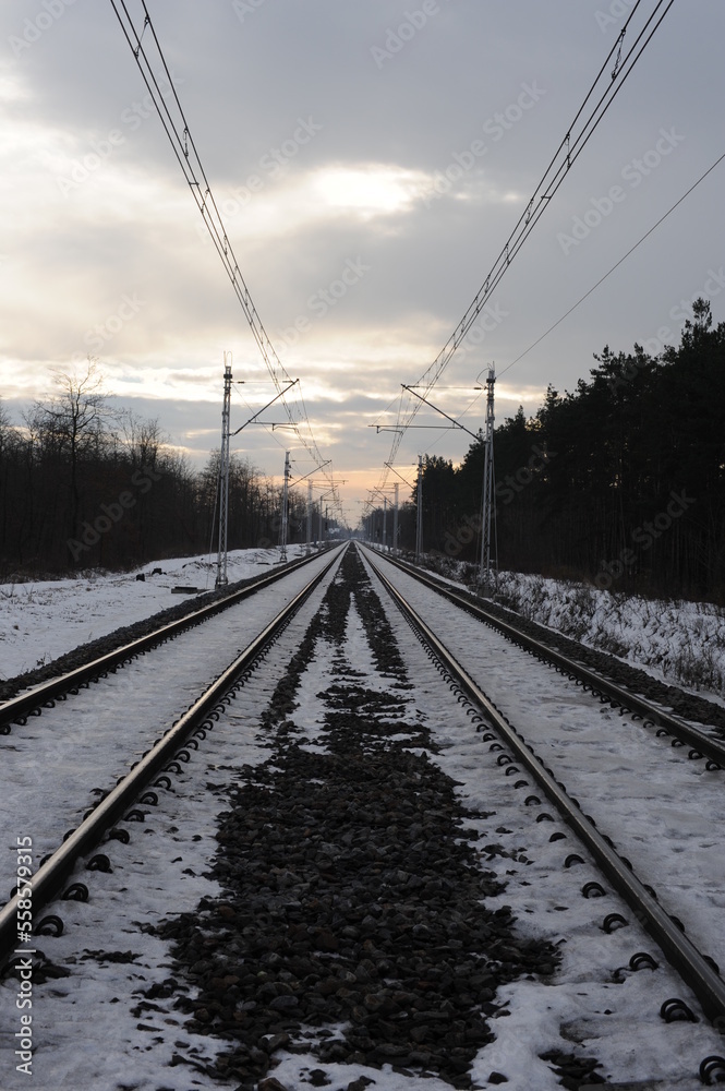 Iron rails of a railway near a train station of a railroad in winter with snow in Europe Iron rails of a railway near a train station of a railroad in winter with snow in Europe