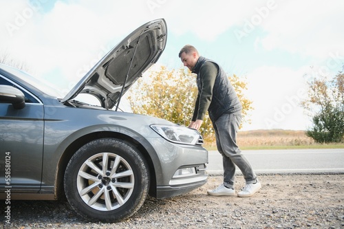 Принти на полотні Man repairing a broken car by the road