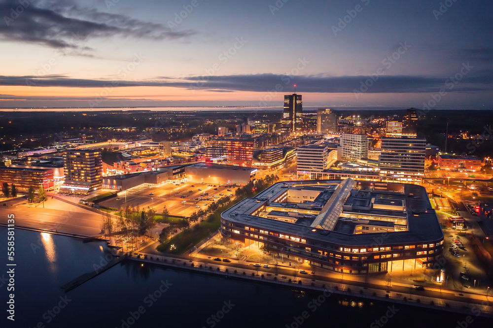 Almere city center illuminated at dusk. Suburban city near Amsterdam, The Netherlands. Aerial view.
